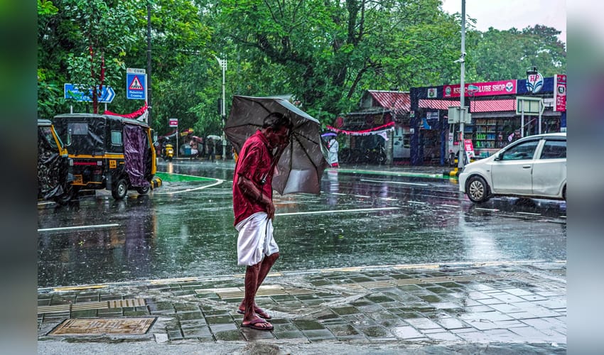 Kochi : A man walks under an umbrella amid heavy rainfall