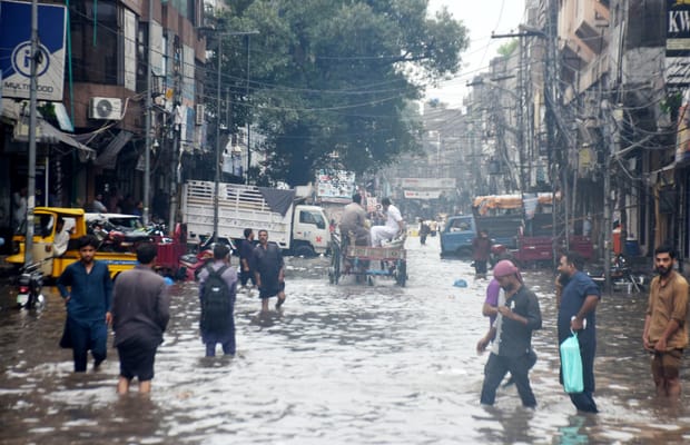 Lahore: Commuters make way through flooded roads after rain