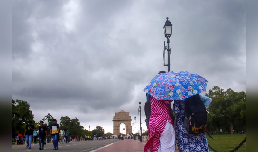 New Delhi: Commuters stroll at India Gate as clouds hover in the sky