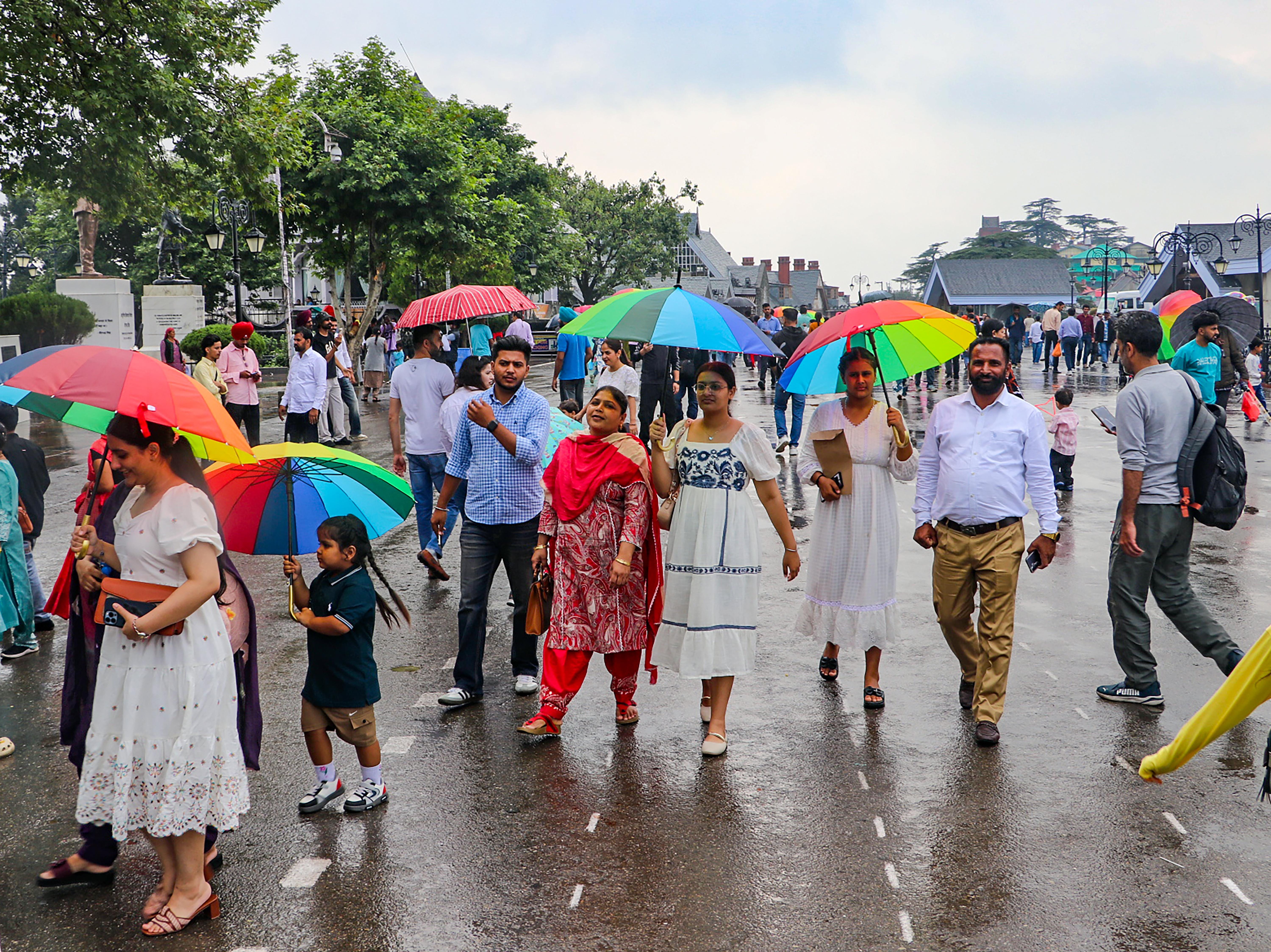 Shimla: Visitors walk with umbrellas amid rain